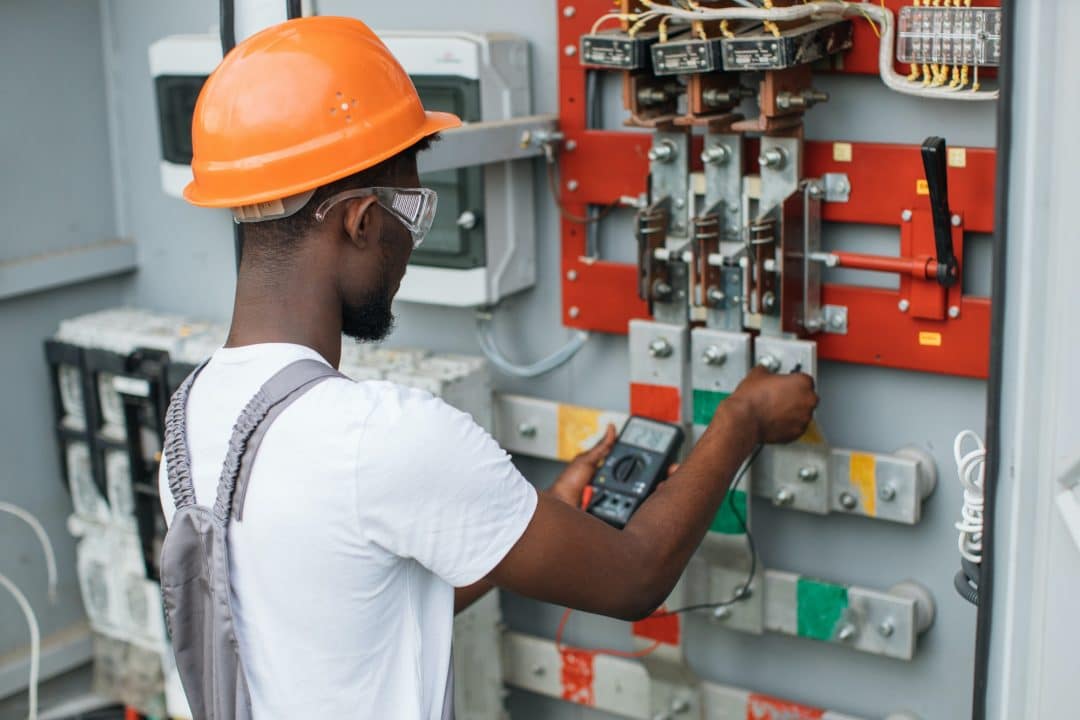 Électricien travaillant sur un tableau électrique, illustration pour le site Isegp